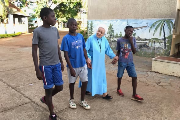Sister Jolanta walking hand in hand with boys